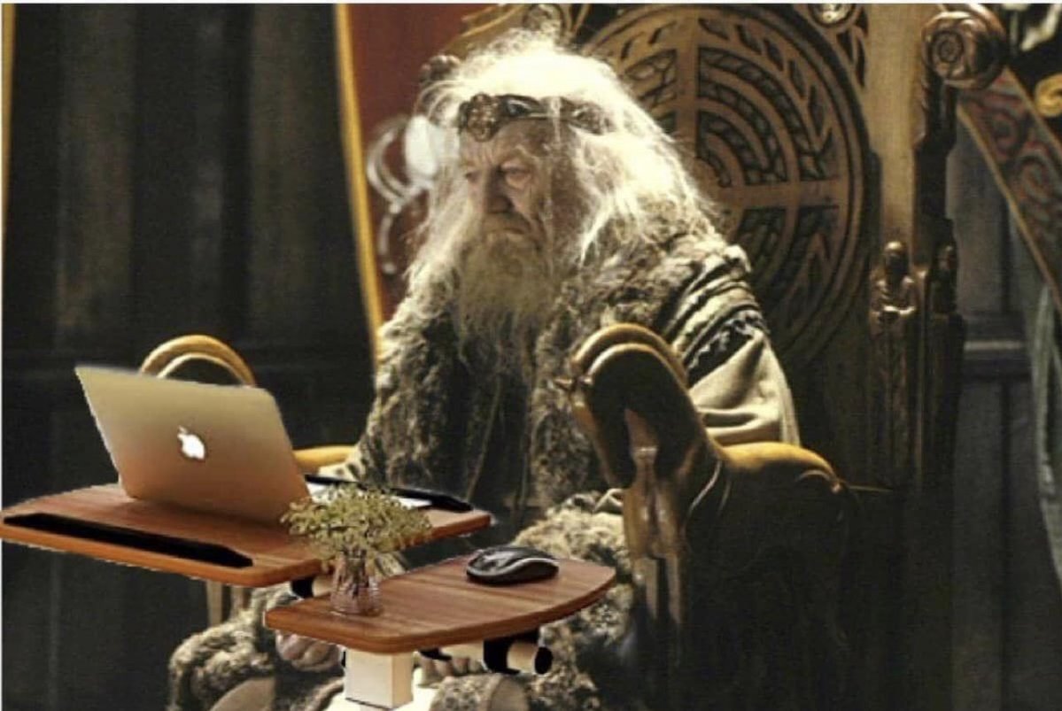 a glum wizard stares in frustration at his laptop